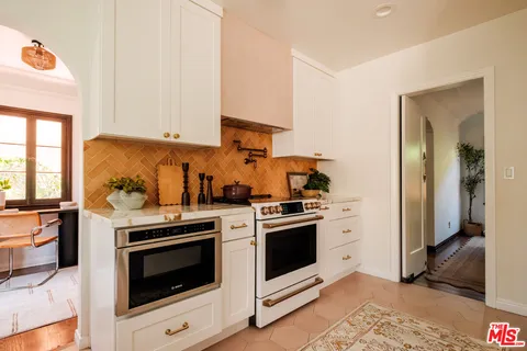 a kitchen with a stove top oven and cabinets