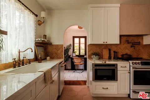 a kitchen with a stove and white cabinets
