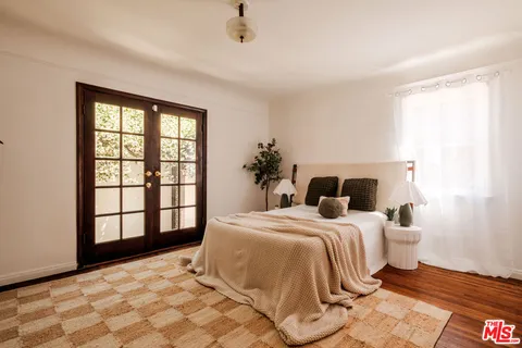 a bedroom with a bed and a painting on the wall