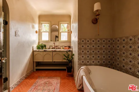 a bedroom with a bed and a potted plant
