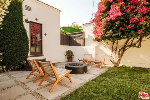 a backyard of a house with table and chairs