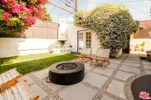 a view of a backyard with table and chairs and potted plants