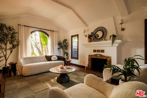 a living room with furniture a fireplace and a large window