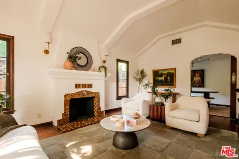 a living room with furniture a fireplace and a flat screen tv