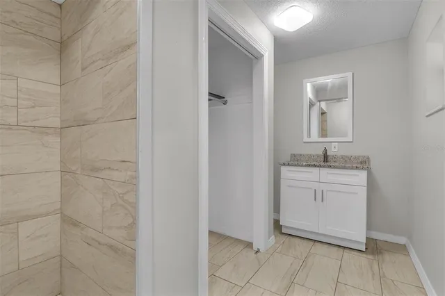 a bathroom with a granite countertop sink a toilet and mirror