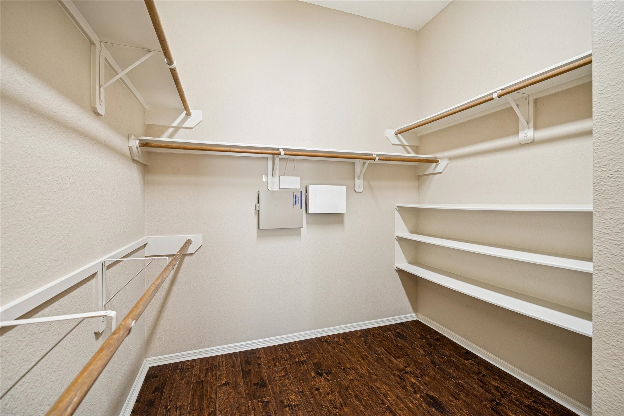 19034 Ranchcrest Drive Magnolia, TX 77355 - Photo 13 of 26 Spacious walk-in closet with hardwood floors, multiple hanging rods, and built-in shelves for ample storage.