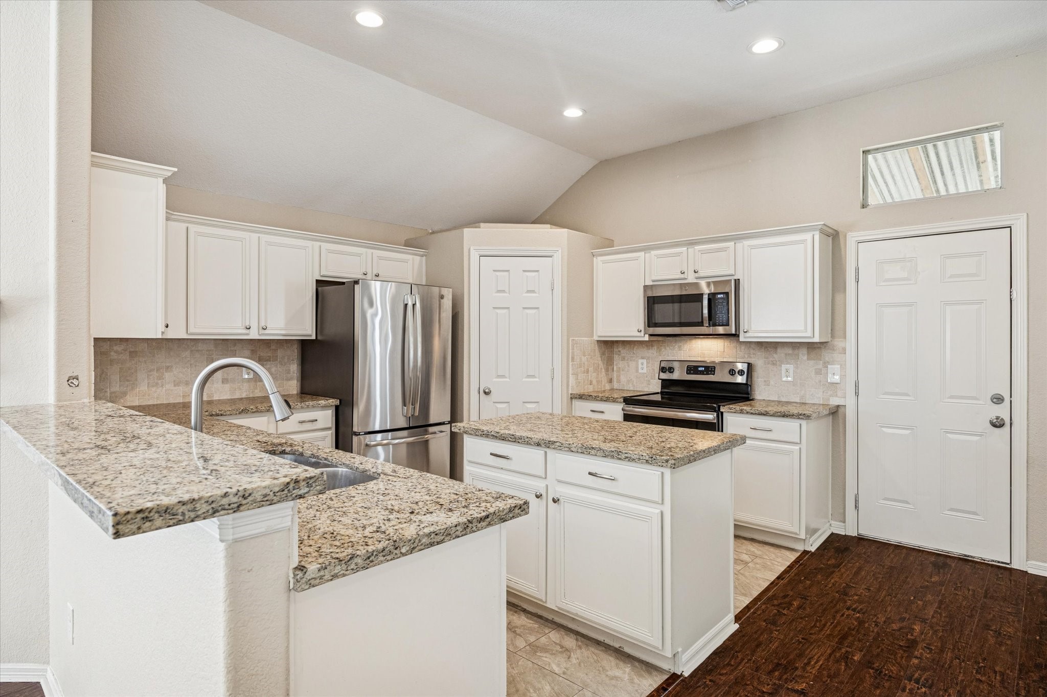 19034 Ranchcrest Drive Magnolia, TX 77355 - Photo 4 of 26 This modern kitchen features stainless steel appliances, granite countertops, and ample cabinet space. It has a central island for additional workspace and a bright, open layout with recessed lighting.