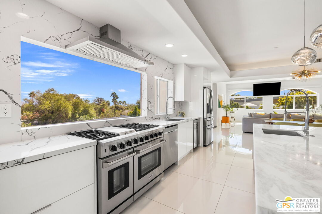 775 West Racquet Club Road Palm Springs, CA 92262 - Photo 12 of 38 a kitchen with stainless steel appliances kitchen island granite countertop a stove and a sink