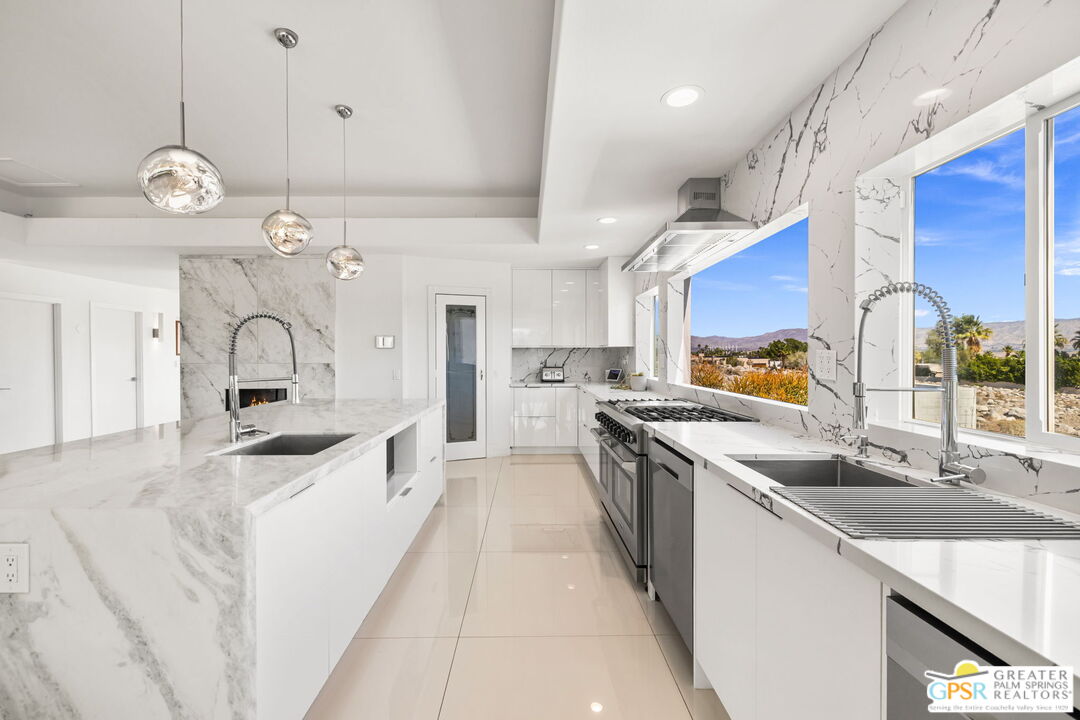 775 West Racquet Club Road Palm Springs, CA 92262 - Photo 15 of 38 a large kitchen with stainless steel appliances granite countertop a sink and stove