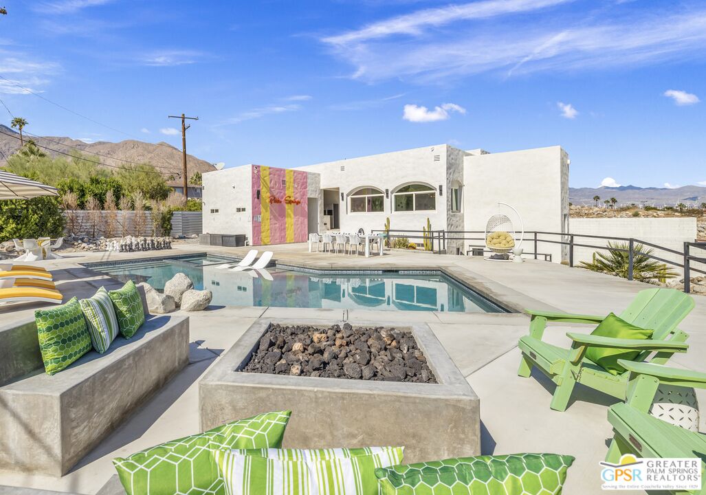 775 West Racquet Club Road Palm Springs, CA 92262 - Photo 5 of 38 a large white building with a swimming pool and outdoor seating
