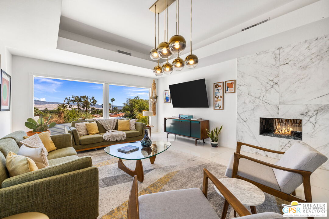 775 West Racquet Club Road Palm Springs, CA 92262 - Photo 10 of 38 a living room with furniture a flat screen tv and a fireplace