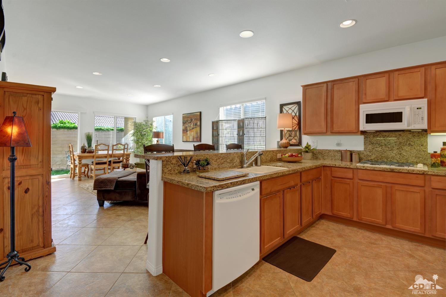 49568 Minelli Street Indio, CA 92201 - Photo 13 of 29 a kitchen with stainless steel appliances granite countertop a sink stove and refrigerator
