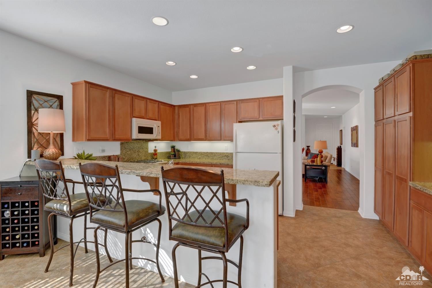 49568 Minelli Street Indio, CA 92201 - Photo 14 of 29 a kitchen with stainless steel appliances granite countertop a refrigerator and a stove top oven