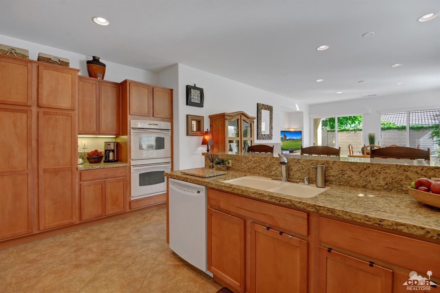 49568 Minelli Street Indio, CA 92201 - Photo 15 of 29 a kitchen with stainless steel appliances granite countertop a sink stove and refrigerator