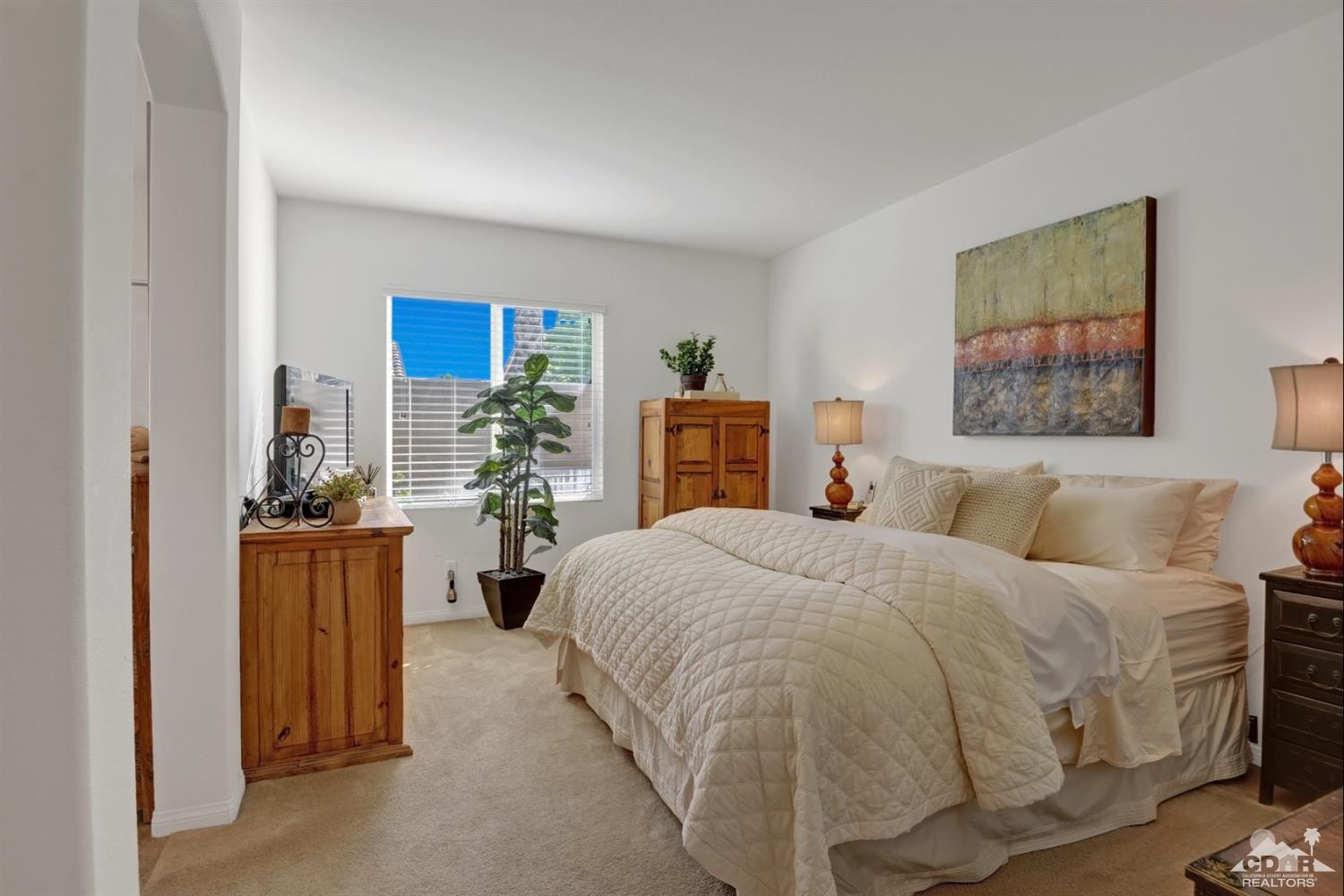 49568 Minelli Street Indio, CA 92201 - Photo 18 of 29 a bedroom with a large bed and a couch