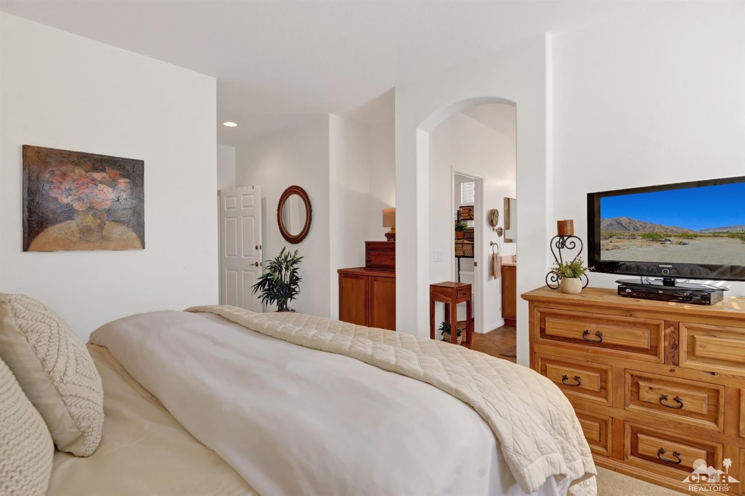 49568 Minelli Street Indio, CA 92201 - Photo 19 of 29 a bedroom with a bed and a flat screen tv