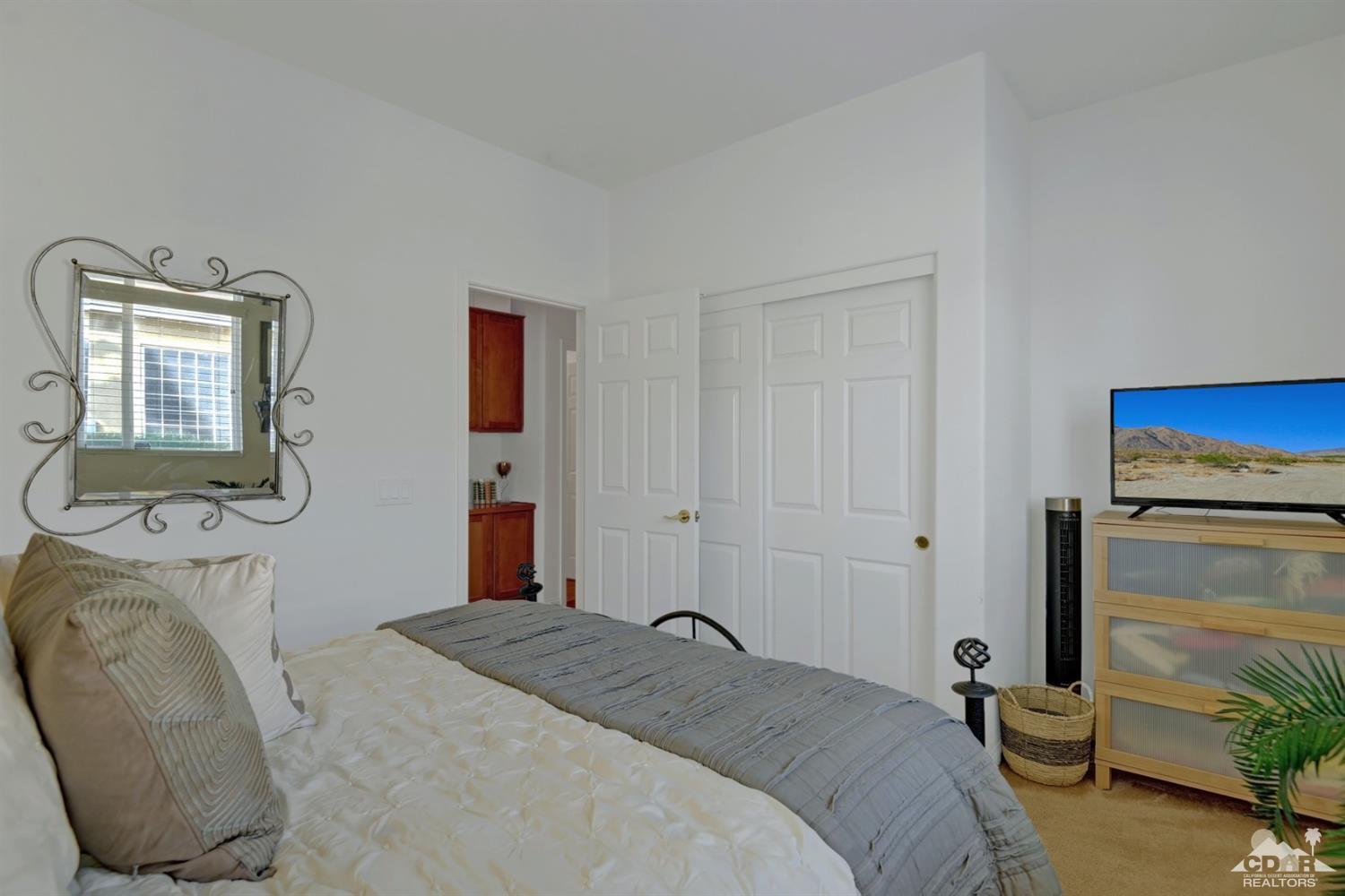 49568 Minelli Street Indio, CA 92201 - Photo 24 of 29 a bedroom with a bed and a chair