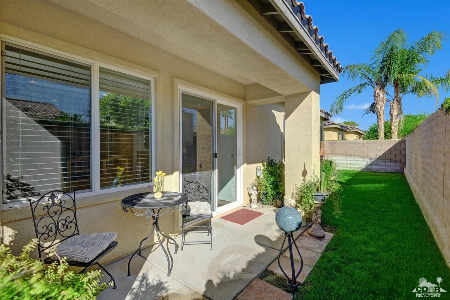 49568 Minelli Street Indio, CA 92201 - Photo 28 of 29 a view of a patio with table and chairs potted plants and floor to ceiling window