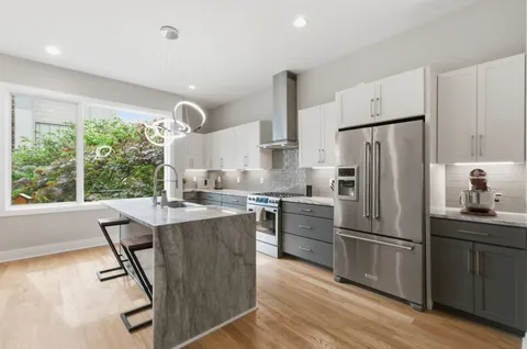 a kitchen with kitchen island a large counter top space appliances and a window