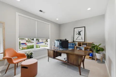 a work room with furniture and a potted plant