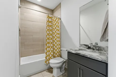a bathroom with a granite countertop sink toilet and shower