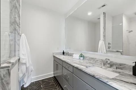 a bathroom with a granite countertop sink and a mirror