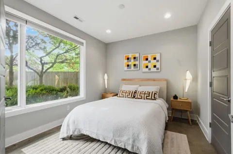 a bed sitting in a bedroom next to a window