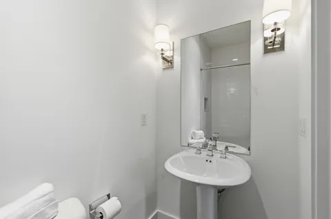 a bathroom with a sink mirror and toilet