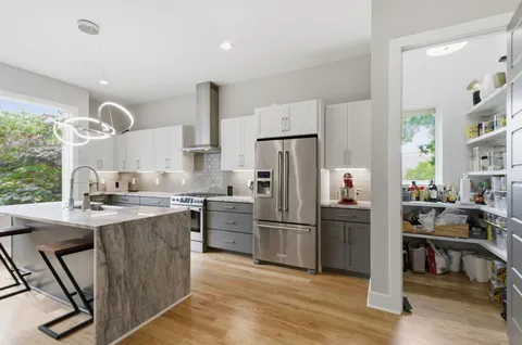 a kitchen with kitchen island a refrigerator stove and sink