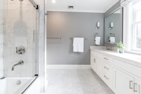 a bathroom with a bathtub sink and mirror