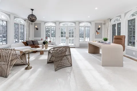 a living room with furniture and large windows