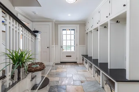 a hallway with a potted plant on the counter and a window