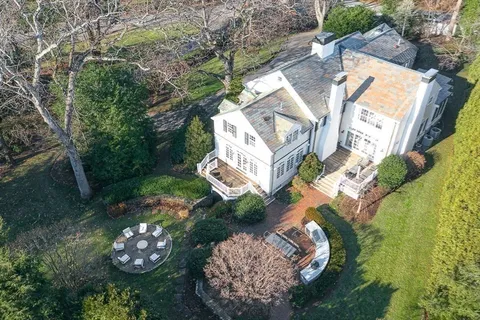 an aerial view of a house with a yard swimming pool and outdoor seating