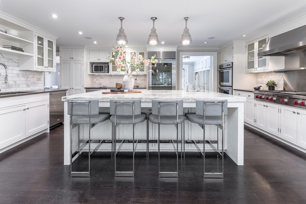 64 Albion Road Wellesley, MA 02481 - Photo 6 of 26 a kitchen with stainless steel appliances kitchen island granite countertop a table and chairs in it