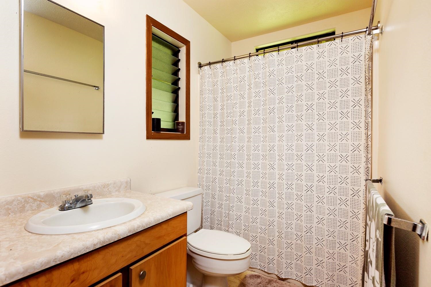 1034 Kaupakalua Road Haiku, HI 96708 - Photo 13 of 21 a bathroom with a sink a toilet and shower curtain