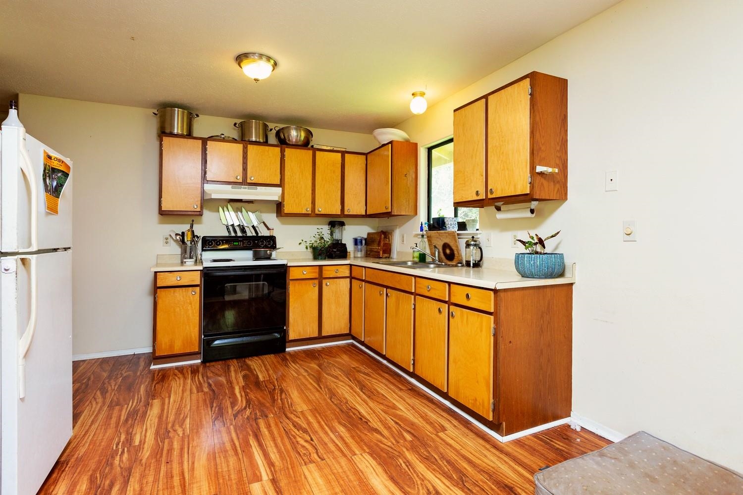 1034 Kaupakalua Road Haiku, HI 96708 - Photo 10 of 21 a kitchen with stainless steel appliances a sink wooden floor cabinets and a counter top space