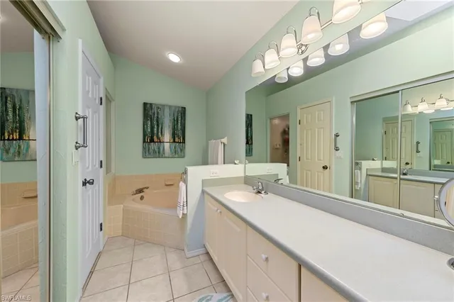 a spacious bathroom with a sink a large mirror and a bathtub