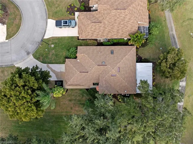 an aerial view of a house with a yard and trees