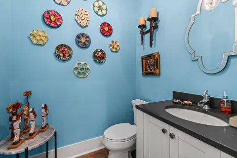 a bathroom with a sink a toilet and a chandelier
