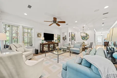 a living room with furniture ceiling fan and a flat screen tv