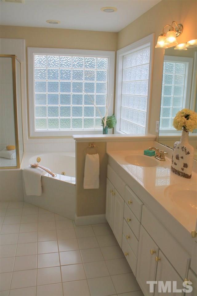 7712 Wilderness Road Raleigh, NC 27613 - Photo 16 of 25 a bathroom with a tub sink and window