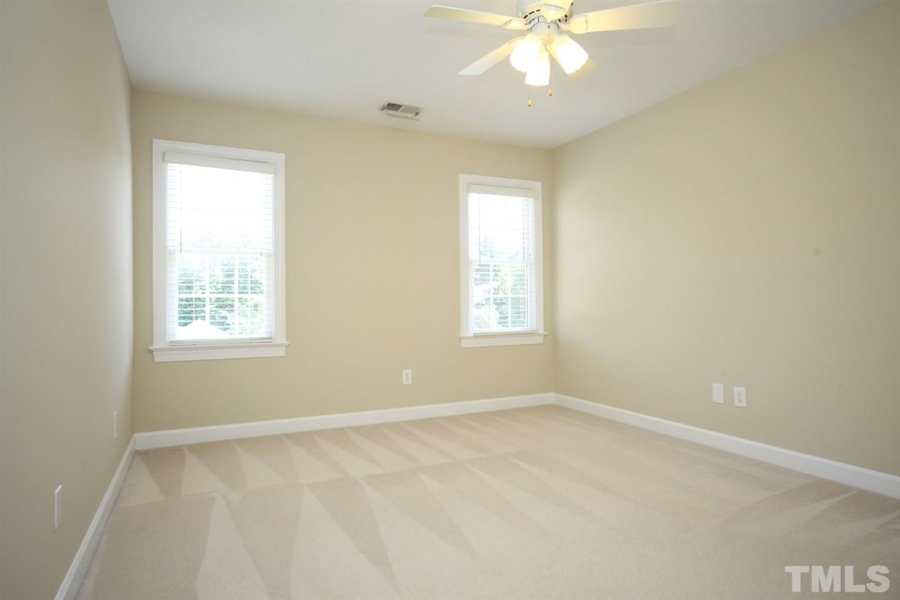 7712 Wilderness Road Raleigh, NC 27613 - Photo 18 of 25 an empty room with windows and fan