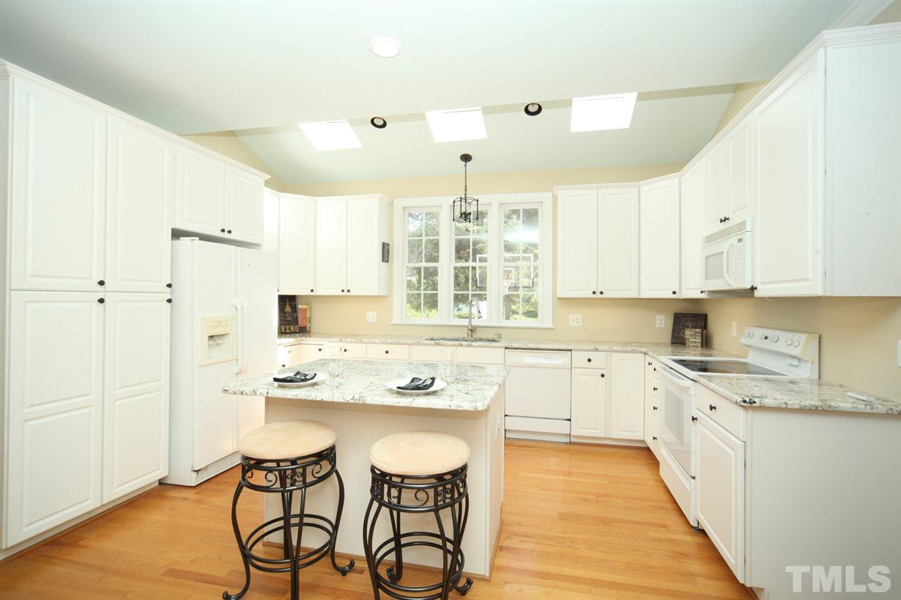7712 Wilderness Road Raleigh, NC 27613 - Photo 6 of 25 a kitchen with stainless steel appliances granite countertop a stove a sink dishwasher and a refrigerator with wooden floor