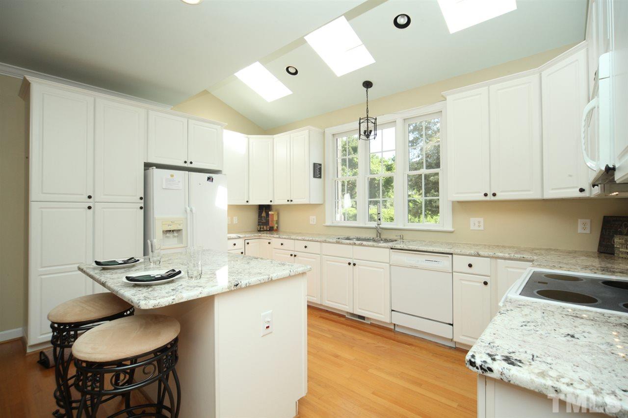 7712 Wilderness Road Raleigh, NC 27613 - Photo 7 of 25 a kitchen with a sink stove and white cabinets