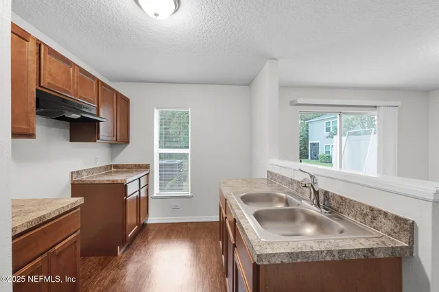 a kitchen with granite countertop a sink stove and refrigerator