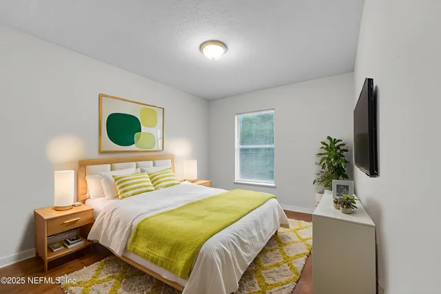 a bedroom with a bed and a potted plant