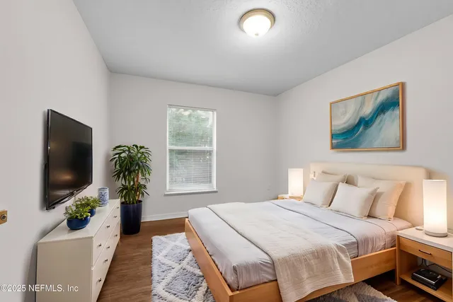 a bedroom with a bed and a flat screen tv