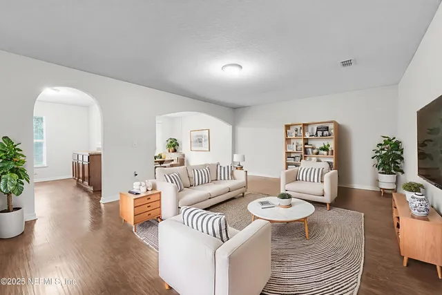 a living room with furniture and a wooden floor