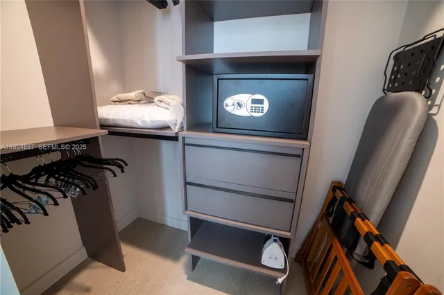 a view of walk in closet with clothes and shoes