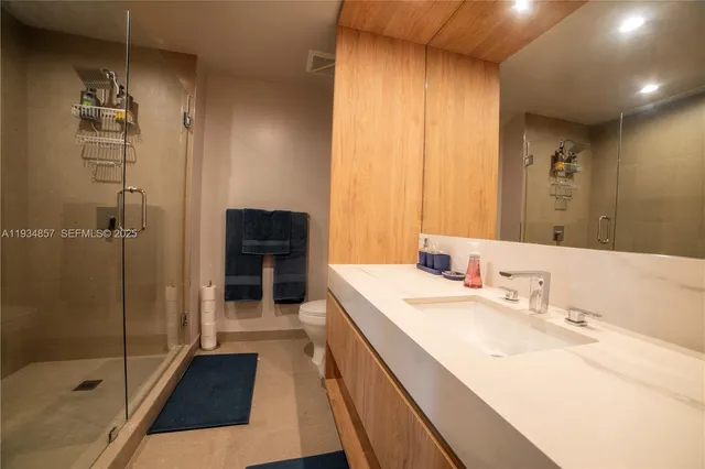a bathroom with a sink a toilet and shower